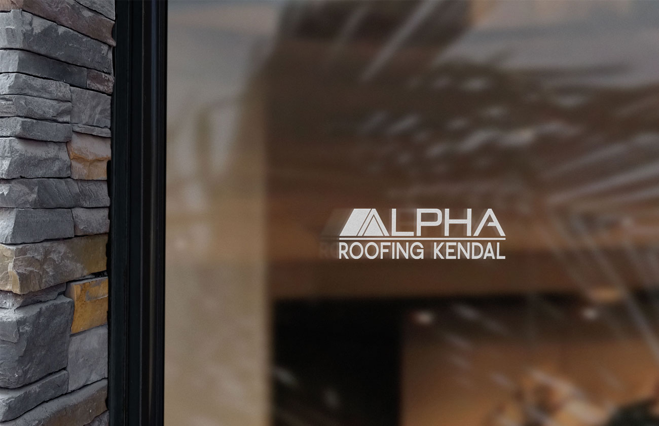 A window displaying alpha roofing kendal logo