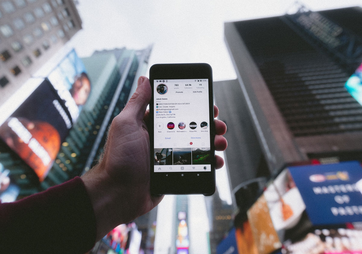 A person holds up their mobile phone screen at Time square