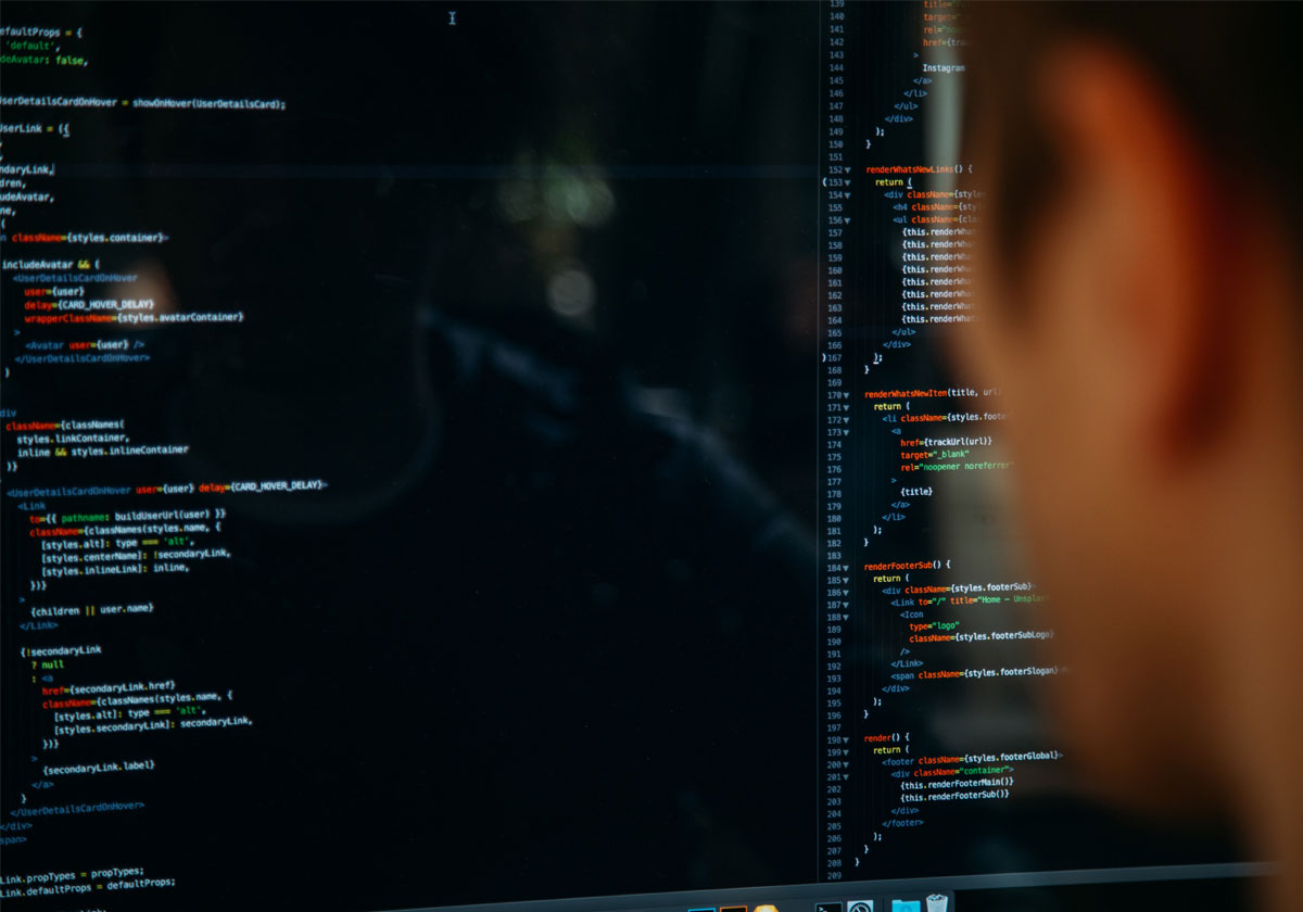 A man looks at a screen displaying html code