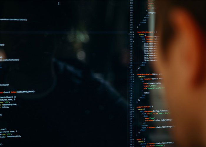 A man looks at lines of html code on a screen