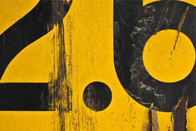 A close up of a sign with a black font on a distressed yellow background