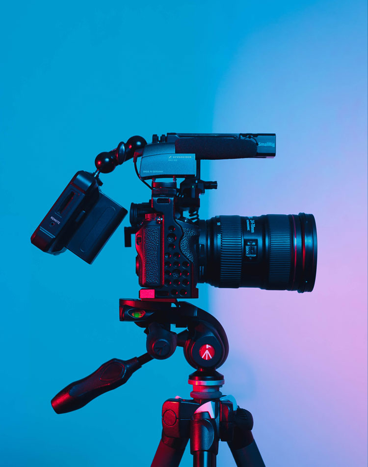 A filmcrew camera in front of a coloured backdrop