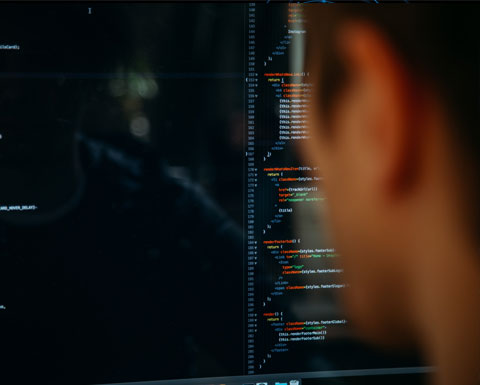A man looks at a screen displaying lines of html code