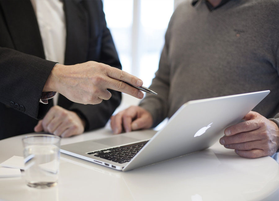 Two people looking at a laptop and discussing a design project